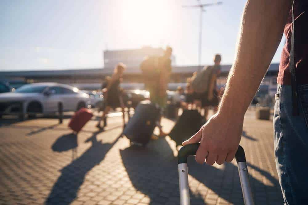 Group,Of,People,Walking,To,Airport,Terminal,At,Summer,Sunset.